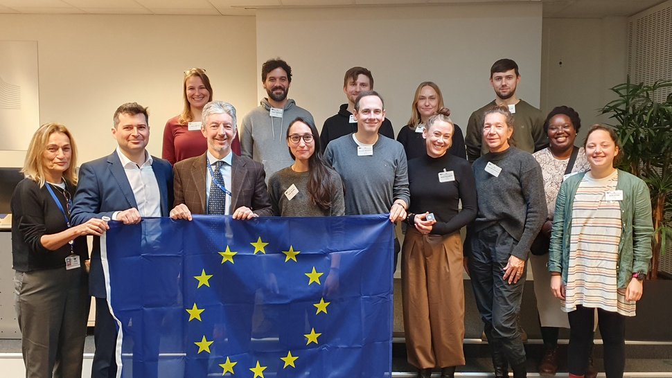 Das Foto zeigt eine Gruppe Menschen mit einer EU-Flagge in der Hand.